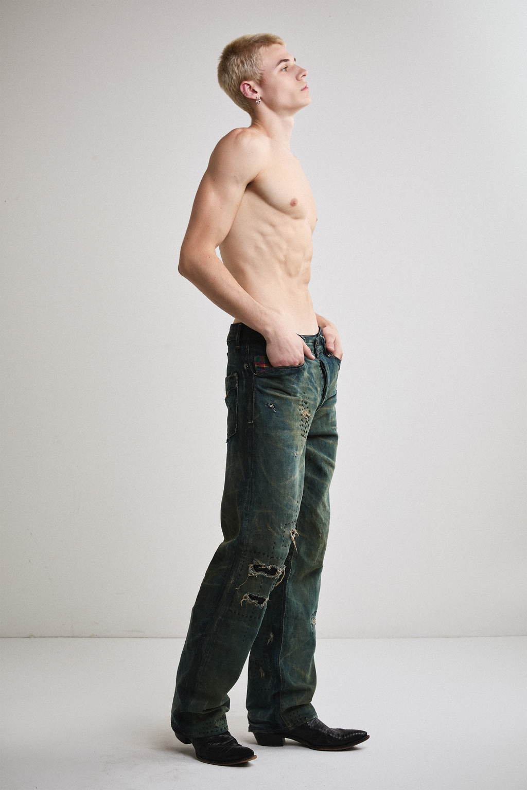 Right side view of Tyler Andersen wearing distressed AOA Sashiko repaired denim