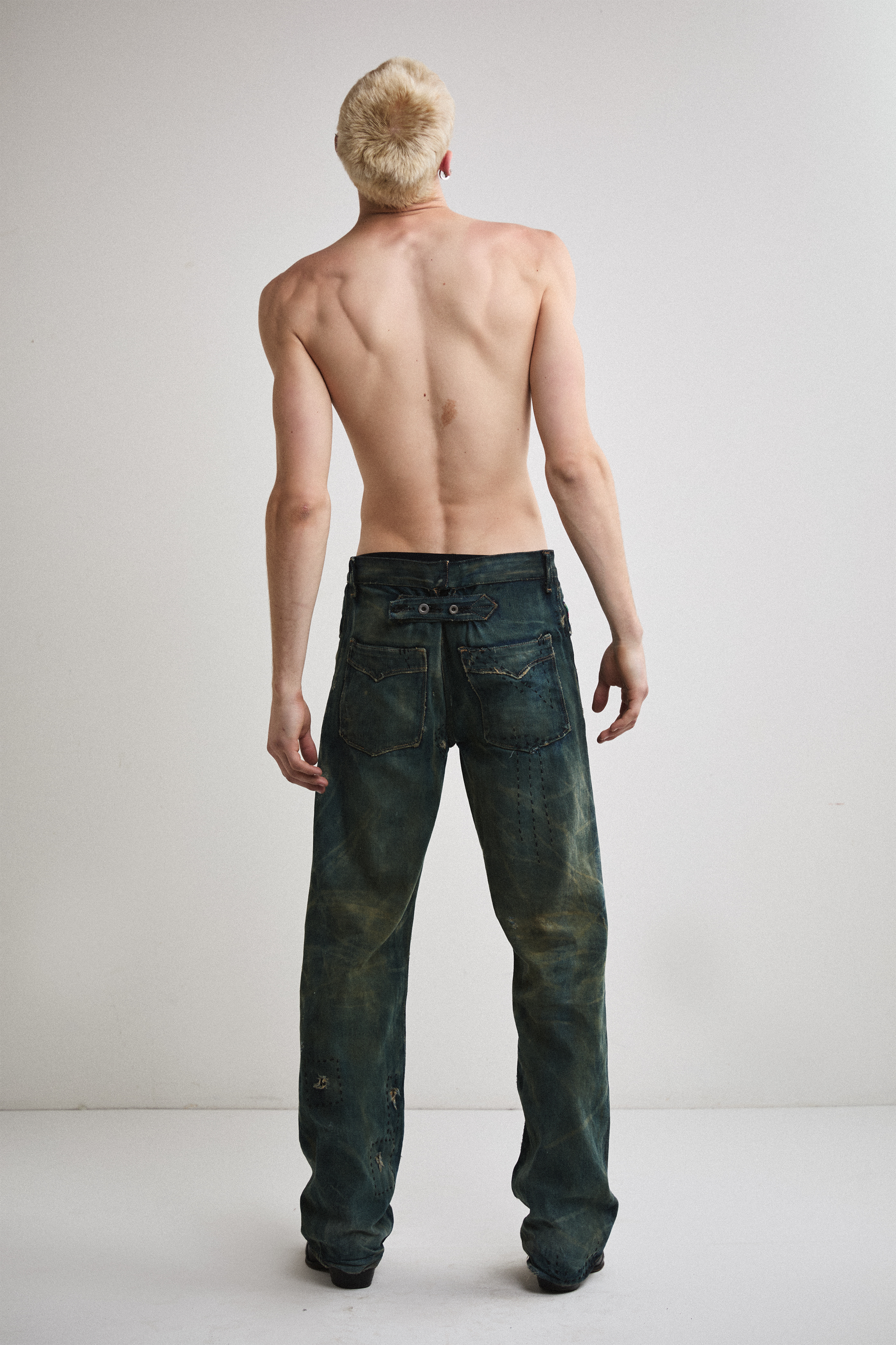 Back view of Tyler Andersen looking up wearing distressed AOA Sashiko repaired denim