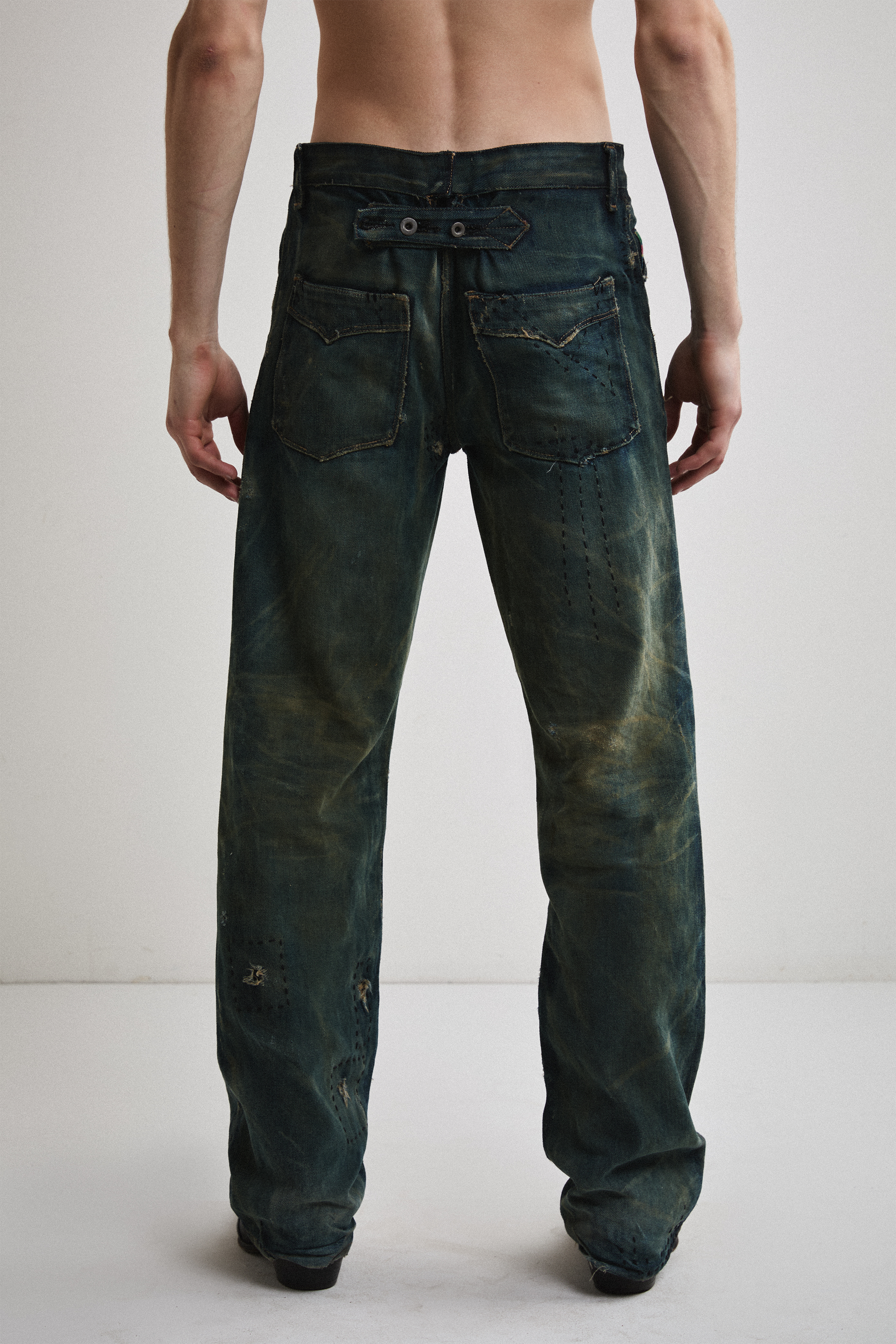 Close-up back view of Tyler Andersen wearing distressed AOA Sashiko repaired denim