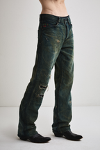 Close-up right side view of Tyler Andersen wearing distressed AOA Sashiko repaired denim