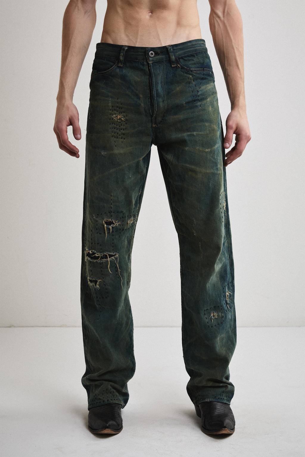 Close-up front view of Tyler Andersen wearing distressed AOA Sashiko repaired denim