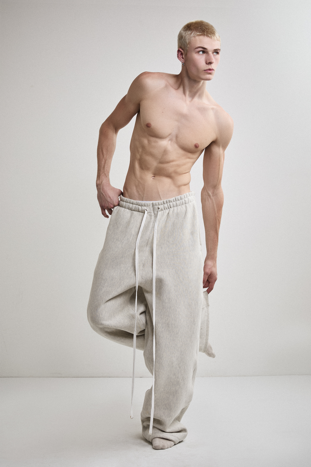 Front view of Tyler Andersen wearing AOA heavyweight grey sweats with leg raised.
