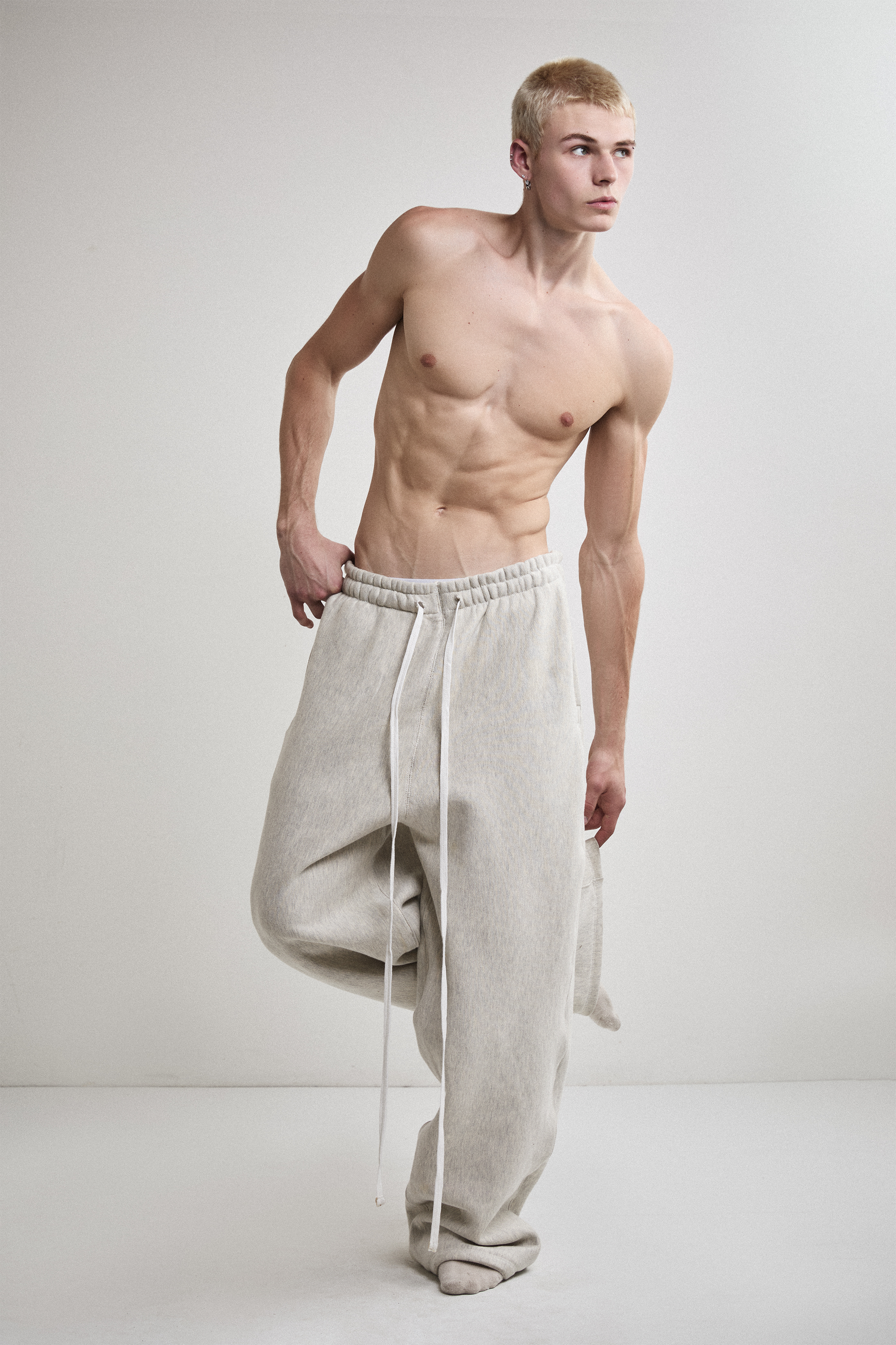 Front view of Tyler Andersen wearing AOA heavyweight grey sweats with leg raised.