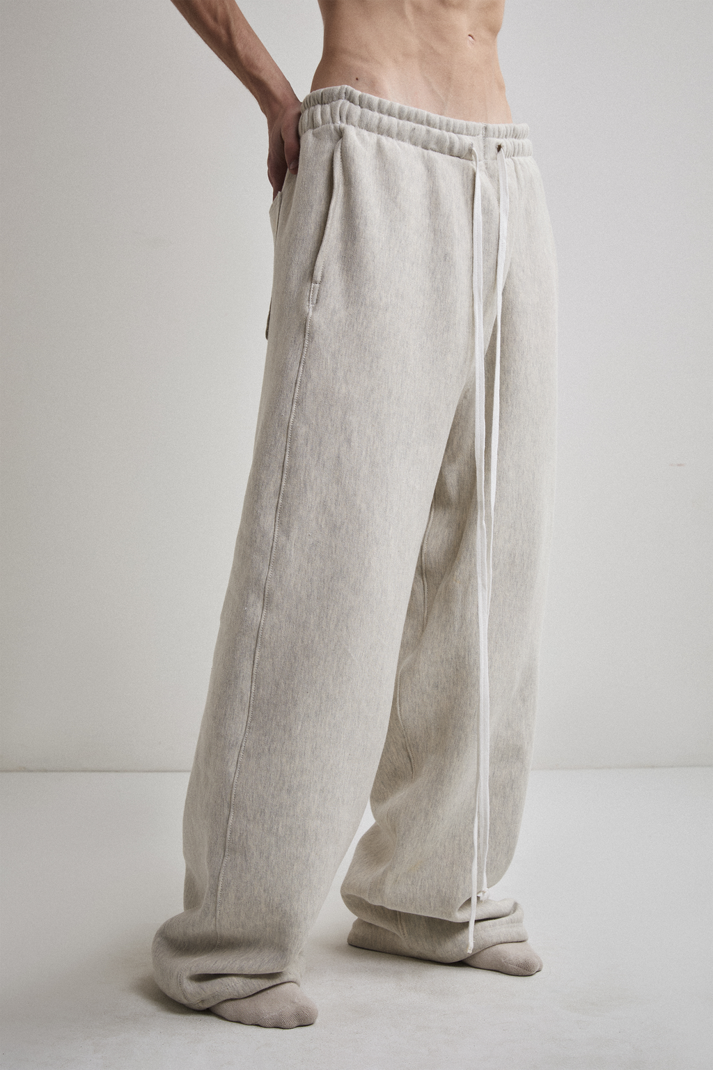 Close-up side view of Tyler Andersen wearing AOA heavyweight grey sweats.