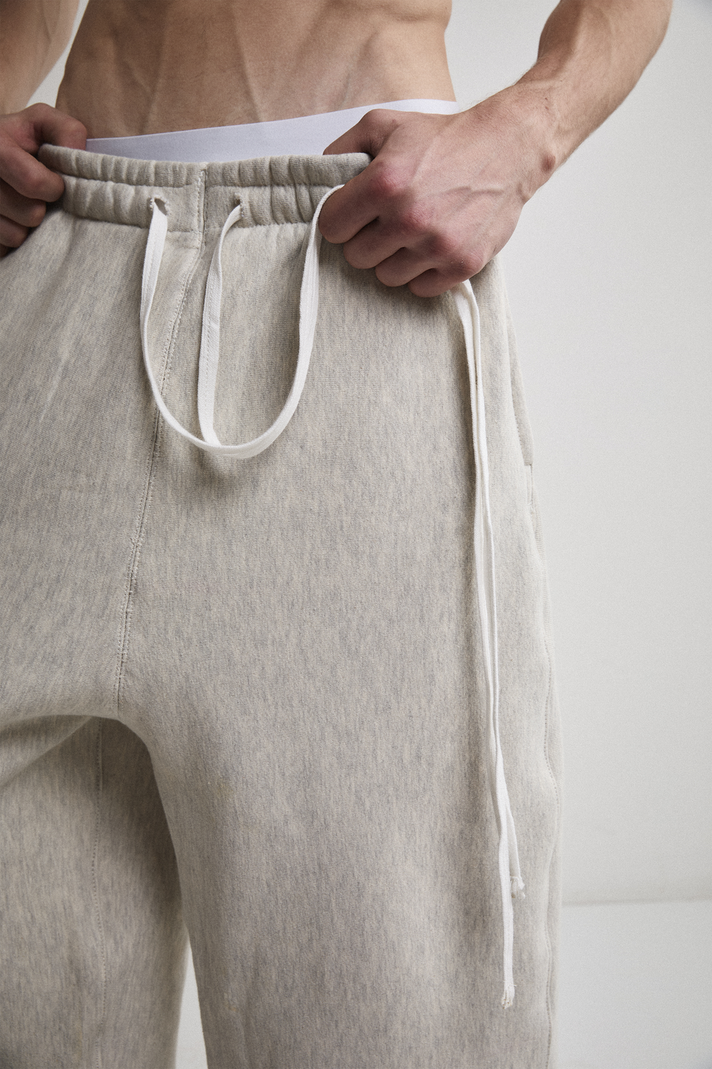 Ultra close-up front view of Tyler Andersen wearing AOA heavyweight grey sweats showing waistband. 
