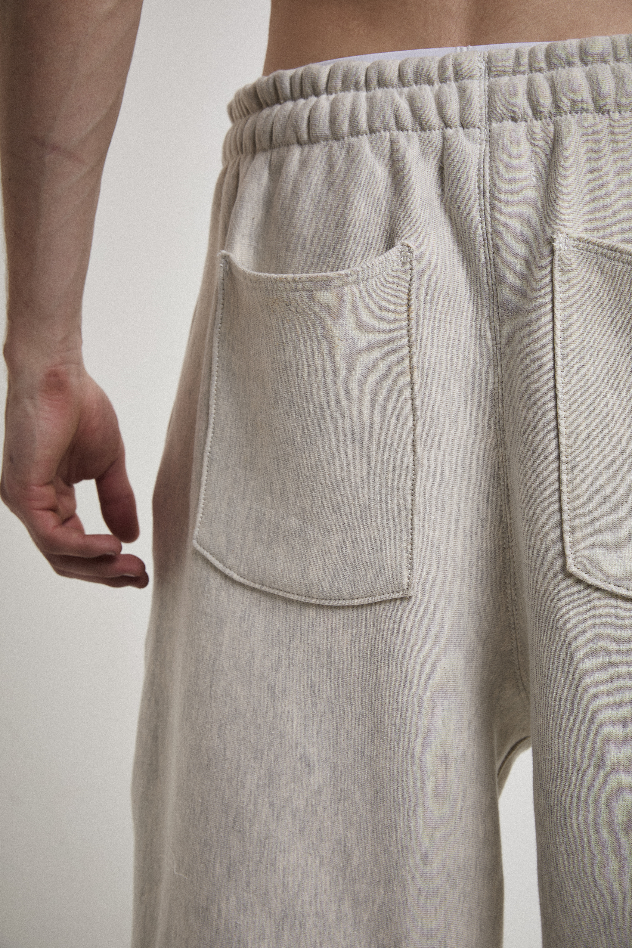 Ultra close-up back view of Tyler Andersen wearing AOA heavyweight grey sweats showing back pockets.
