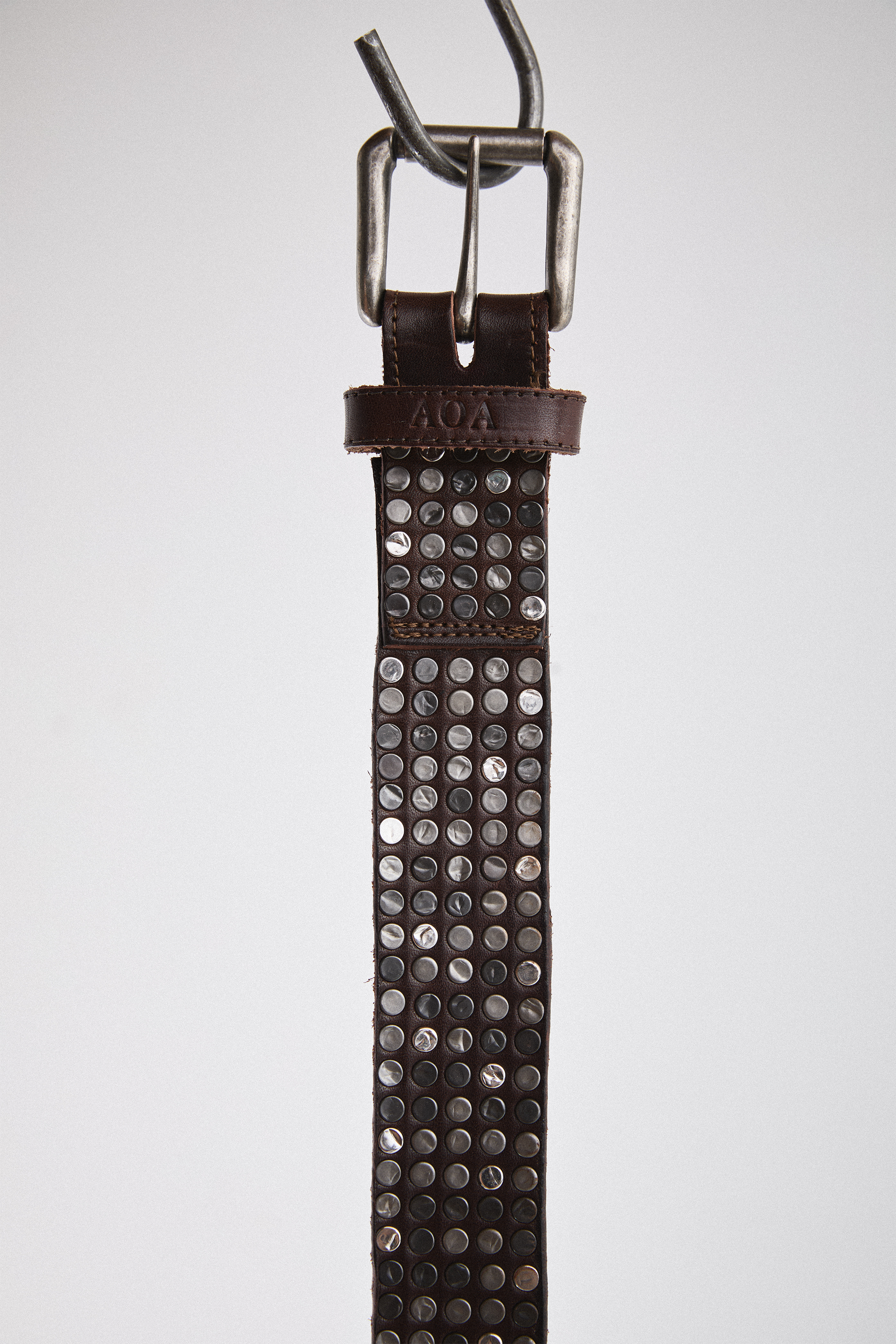 Close-up view of brown AOA belt with rivets.