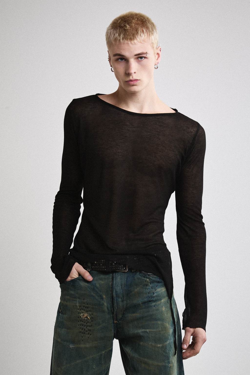 Close-up front view of Tyler Andersen wearing sheer long-sleeve AOA Black top.