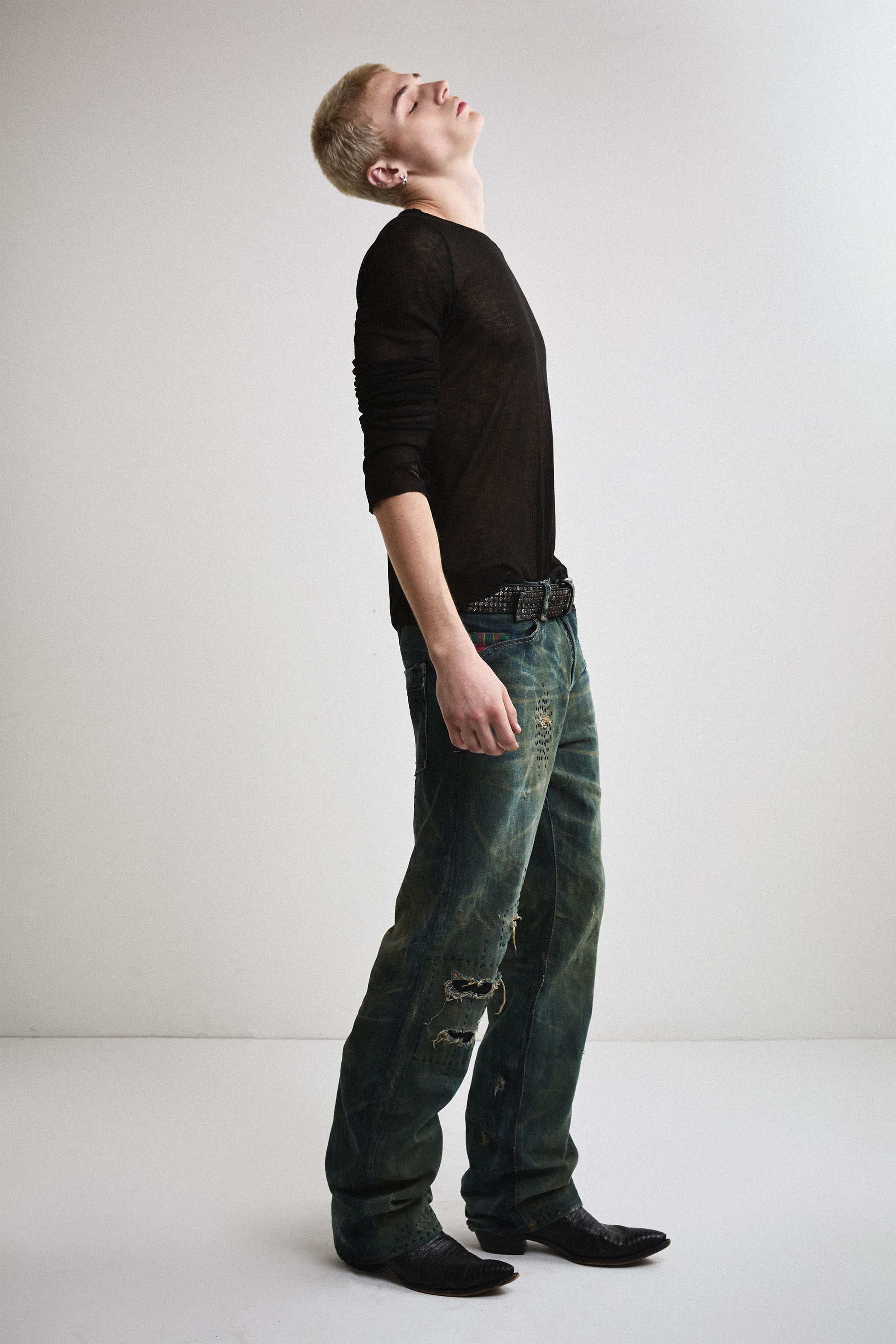 Right side view of Tyler Andersen wearing sheer long-sleeve AOA Black top.