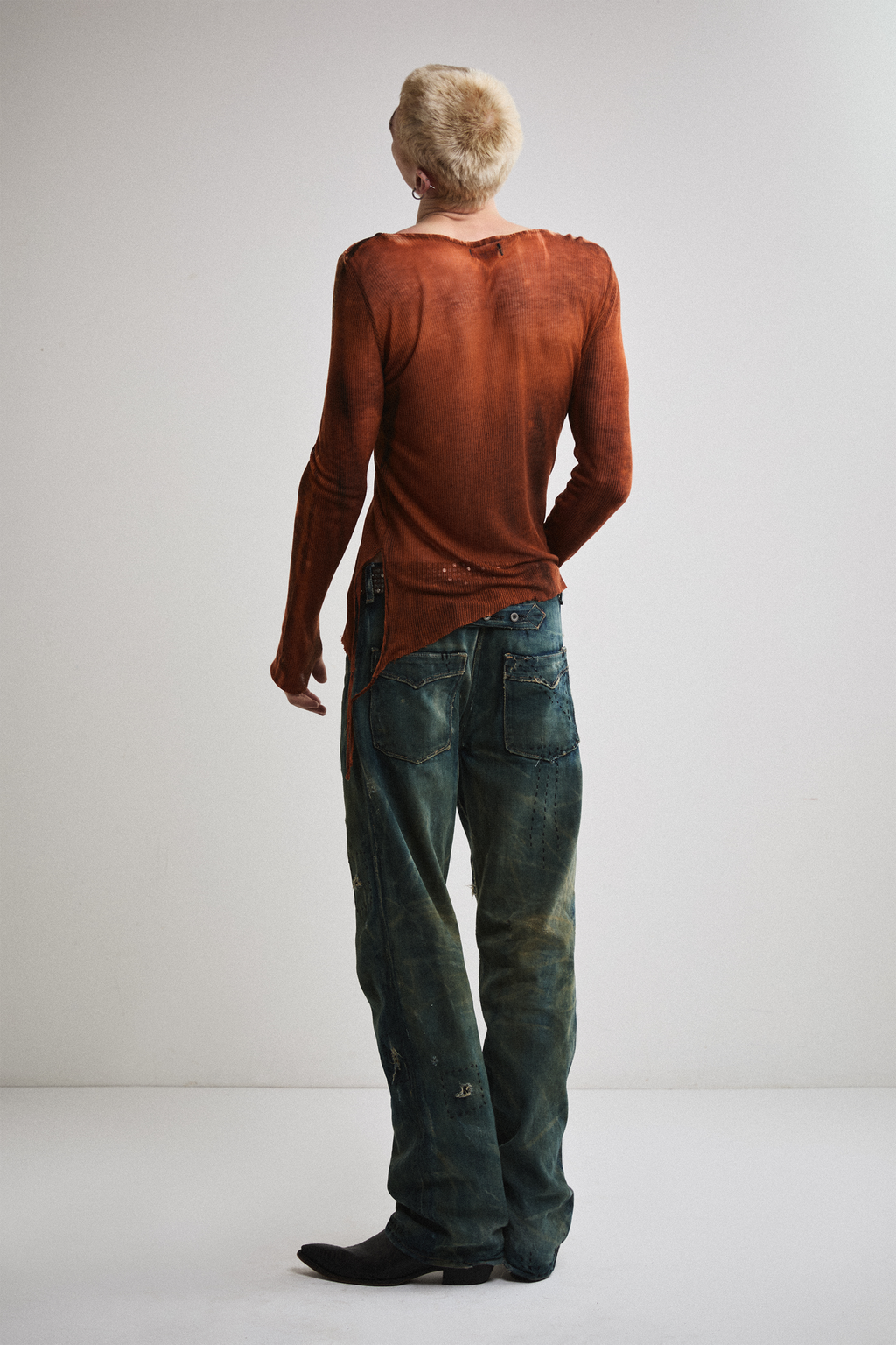 Back view of Tyler Andersen wearing sheer long-sleeve AOA rust top.
