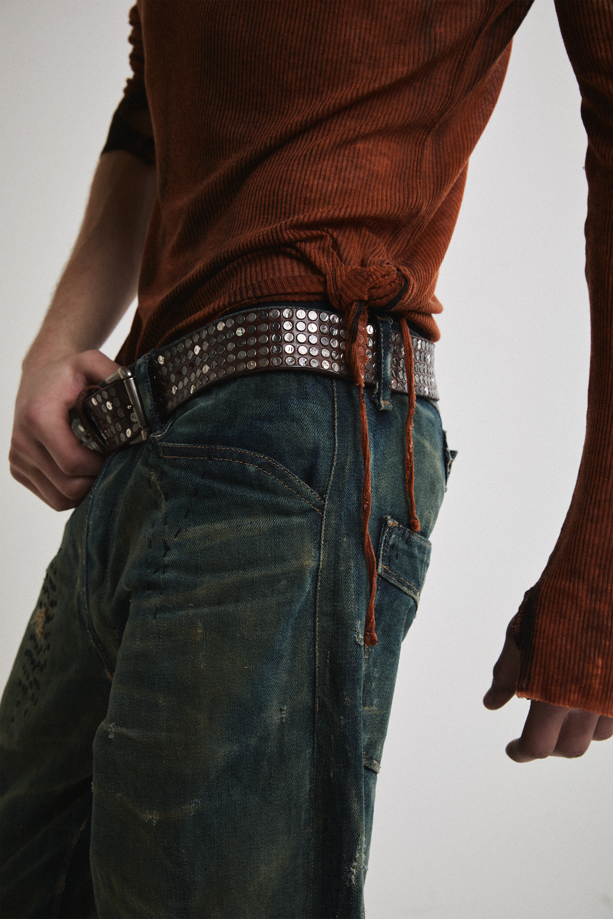 Close-up left side view of Tyler Andersen wearing sheer long-sleeve AOA rust top.