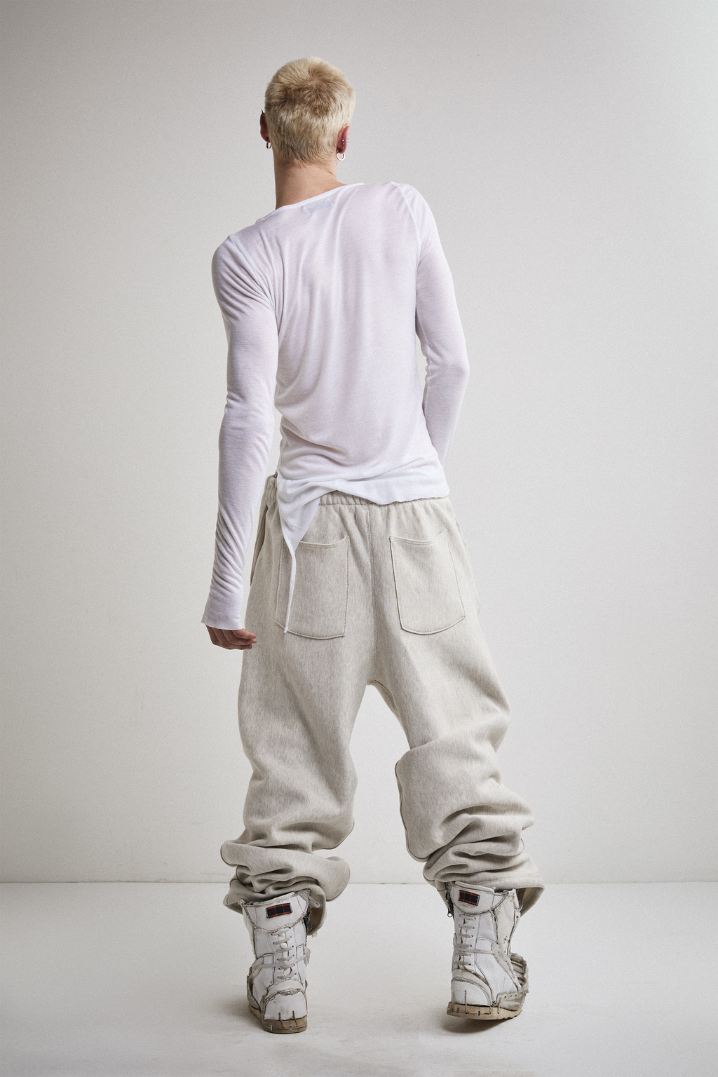 Back view of Tyler Andersen wearing sheer long-sleeve AOA White  top.