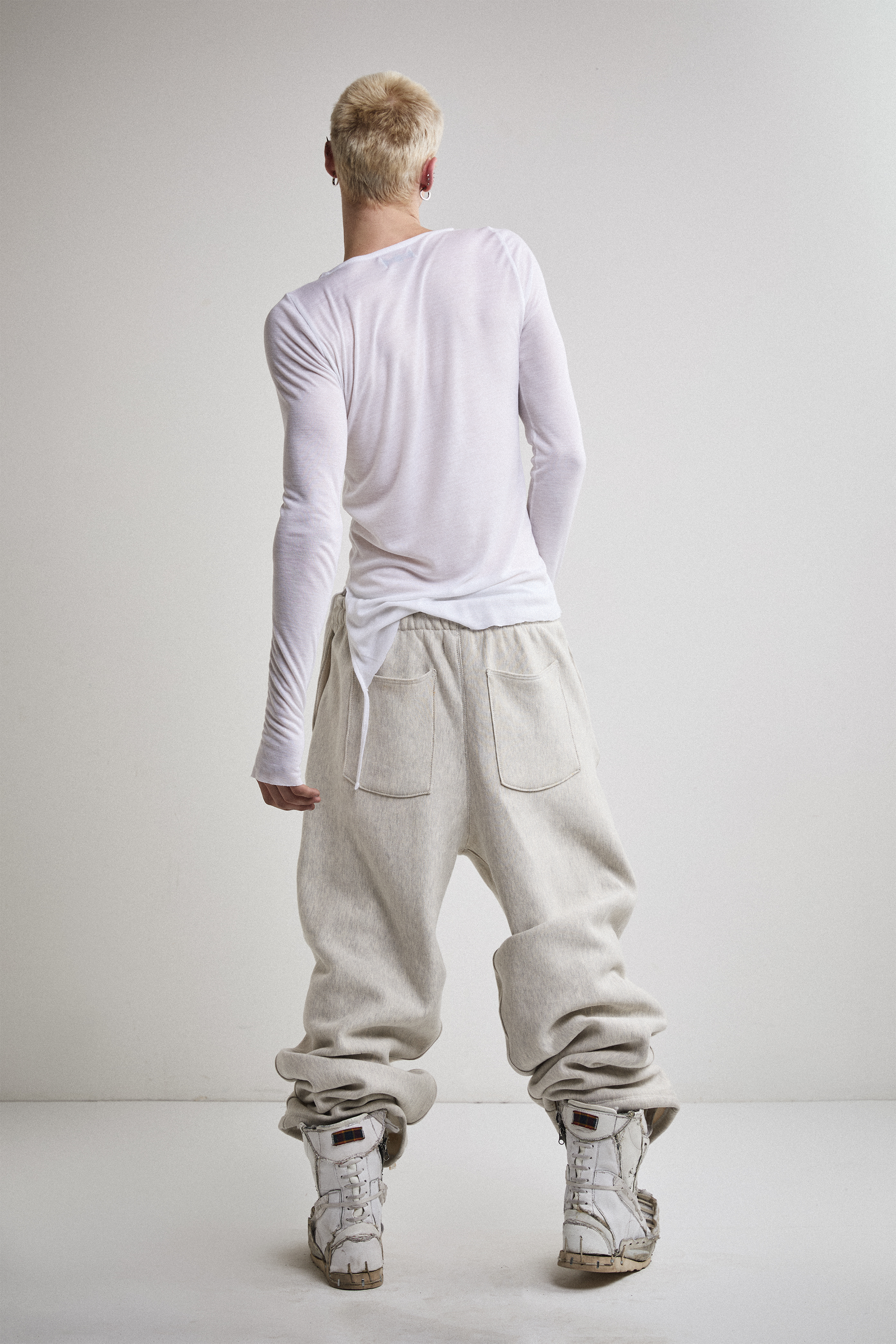 Back view of Tyler Andersen wearing sheer long-sleeve AOA White  top.