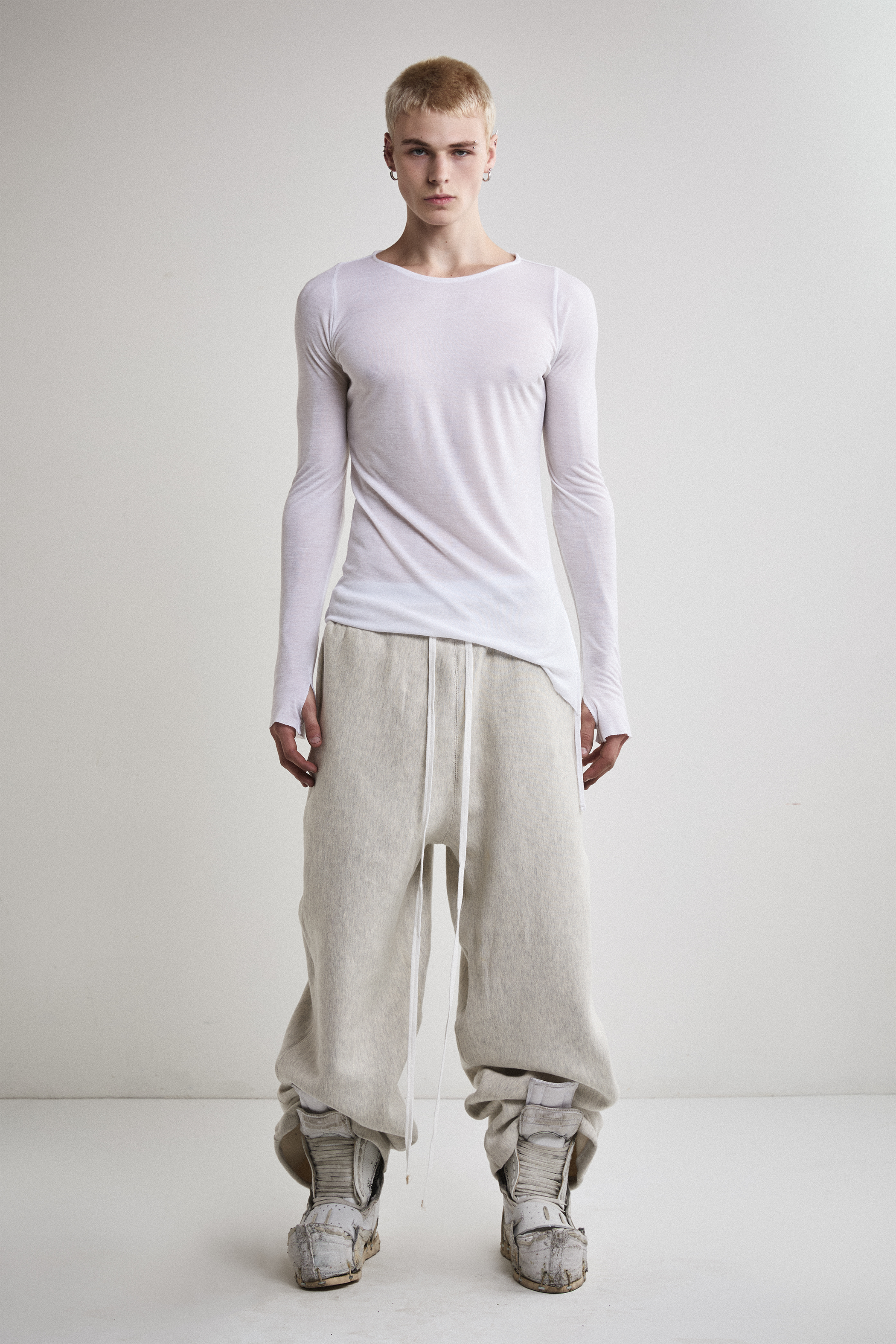 Front view of Tyler Andersen wearing sheer long-sleeve AOA White  top.