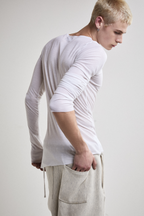 Close-up right side view of Tyler Andersen wearing sheer long-sleeve AOA White  top.