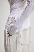 Ultra close-up view of sheer long-sleeve AOA White  top showing tassels.